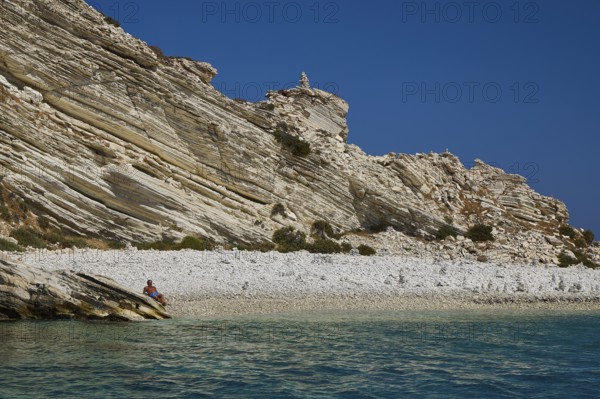 A rocky coastline with clear views of turquoise waters and a blue sky, White Cliffs, White Beach,