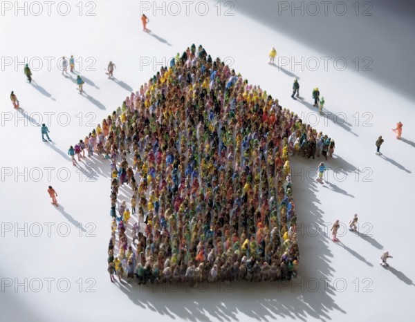 A concept photograph depicting numerous individuals arranged to form the shape of a house. Symbolic