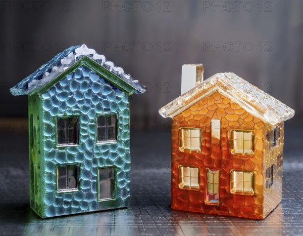 A collection of small glass model houses with cozy lighting, creating a warm and inviting