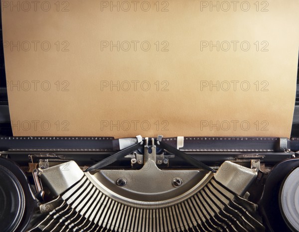 View from above of a retro typewriter equipped with a blank paper sheet, representing creativity,