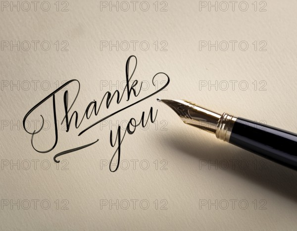 Elegant pen rests alongside a handwritten Thank You card on a wooden surface in soft light.