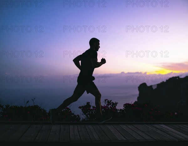 A cinematic silhouette of an athletic man running, representing fitness, endurance, wellness, and