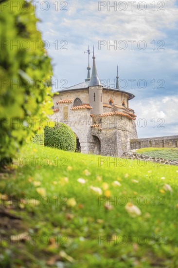 Charming turret on a green meadow in front of a slightly cloudy sky creates a romantic atmosphere,