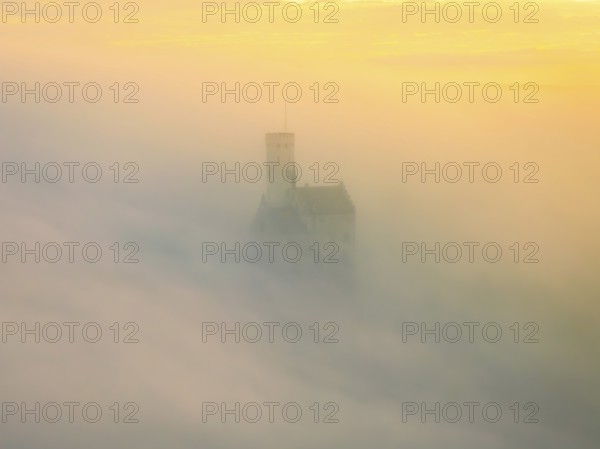 Castle shrouded in mist in the soft light of a sunrise, Lichtenstein Castle, Lichtenstein, Swabian