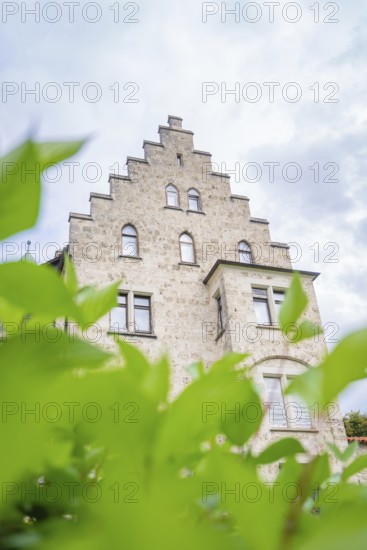An impressive historic building in Gothic style, half hidden by green plants, Lichtenstein Castle,