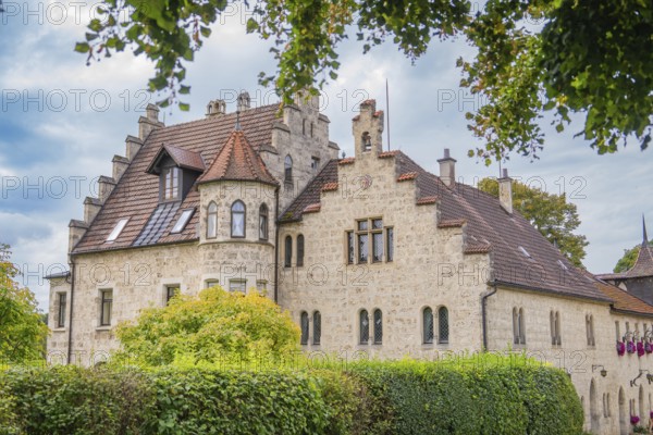 An old building with a red tiled roof and many windows, surrounded by trees, Lichtenstein Castle,