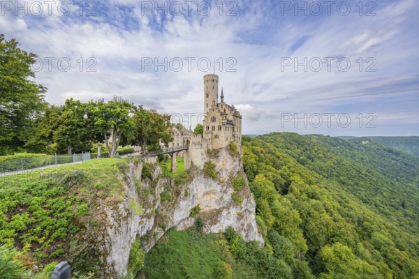 Impressive castle stands on a lush cliff, surrounded by mountains and sky, Lichtenstein Castle,
