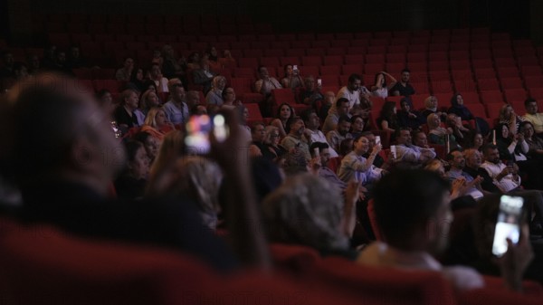 Audience members dance and clap as Turkish singer Coskun Sabah performs during the Türkiye Kültür