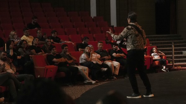 Audience members dance and clap as Turkish singer Coskun Sabah performs during the Türkiye Kültür
