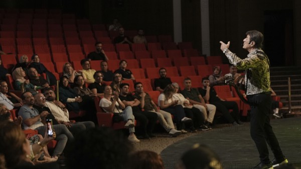 Audience members dance and clap as Turkish singer Coskun Sabah performs during the Türkiye Kültür