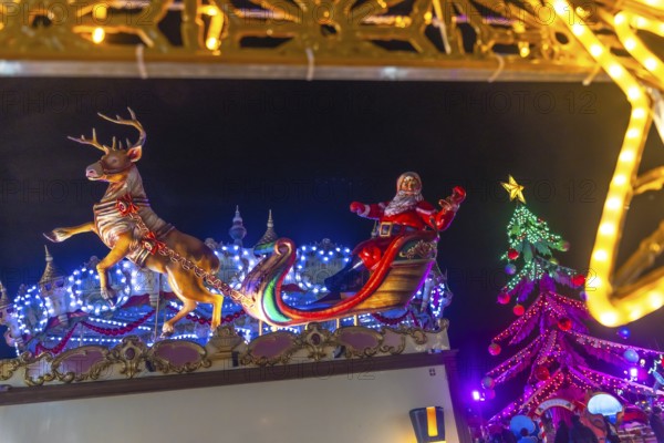 Santa claus figurine waving on a sleigh pulled by a reindeer at the bayonne christmas market in