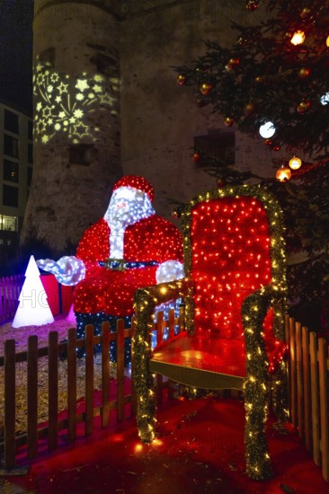 Luminous santa claus installation sitting on his throne during christmas festivities in bayonne,