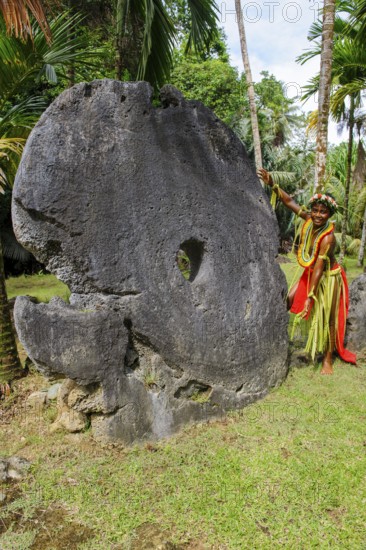 Local boy in traditional traditional costume from Yap Island as size comparison next to oversized