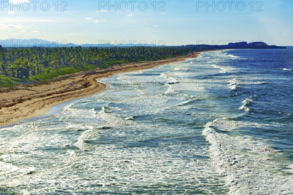 Aerial view of strong surf rolling in with whitecaps at coastal cut-off near Punta Cana, Dominican