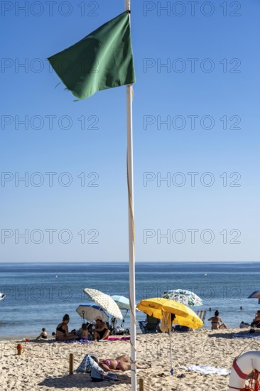 Kilometre-long sandy beach Praia do Barril, on the island off Santa Luzia, green flag indicates