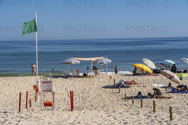 Kilometre-long sandy beach Praia do Barril, on the island off Santa Luzia, green flag indicates