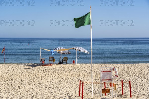 Kilometre-long sandy beach Praia do Barril, on the island off Santa Luzia, green flag indicates