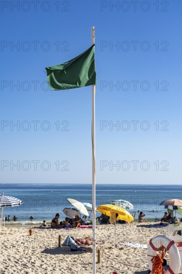 Kilometre-long sandy beach Praia do Barril, on the island off Santa Luzia, green flag indicates