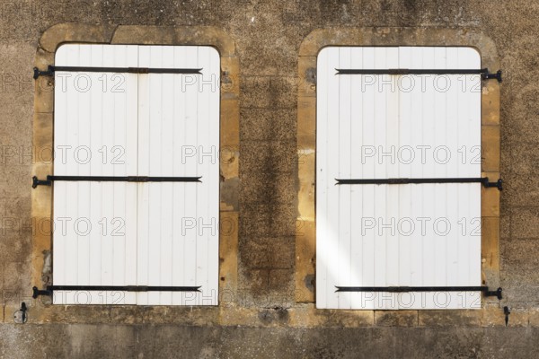 2 white, closed wooden windows, historic house façade, yellow sandstone, Marville, Renaissance
