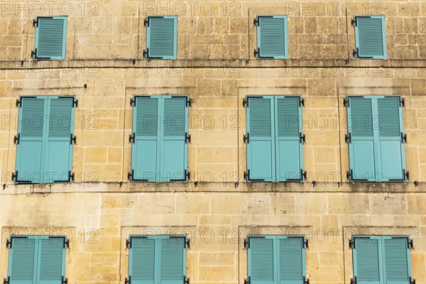 Closed, green shutters, historic house façade, yellow sandstone, Marville, Renaissance village,