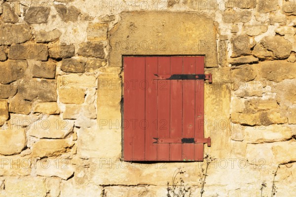 Red wooden window, historic house façade, yellow sandstone, Marville, Renaissance village,