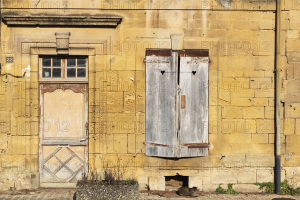 Closed wooden door and windows, historic house façade, yellow sandstone, Marville, Renaissance
