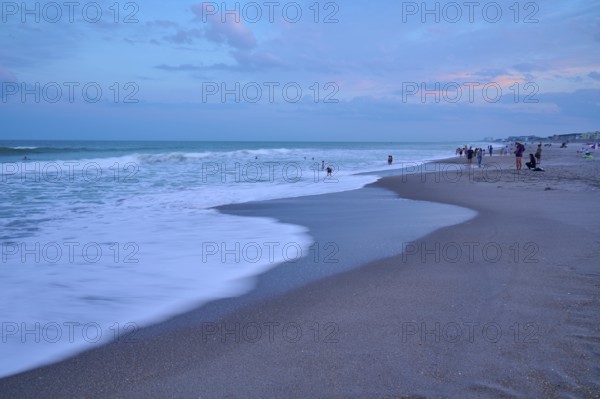 Wave scene on the beach in the evening with people in the background, Cocoa Beach, Port Canaveral,