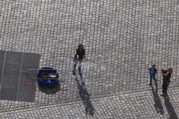 View from the lantern of the Church of Our Lady to the Neumarkt with street artist who delights