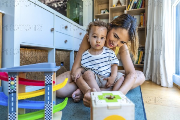 Happy mother and son playing with educational toys, enjoying quality time together in a cozy home