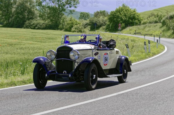 A white and blue classic car with driver on a sunny country road, classic car, car race, Mille