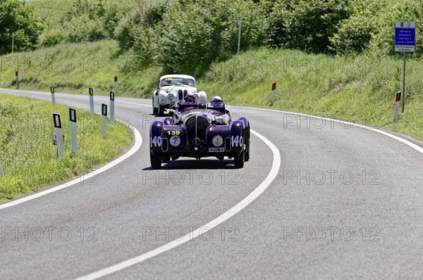 A purple vintage car followed by a white car on a country road, vintage car, car race, Mille
