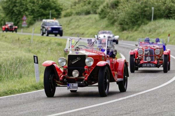 Red classic car in a convoy on a winding country road, classic car, car race, Mille Miglia, 1000