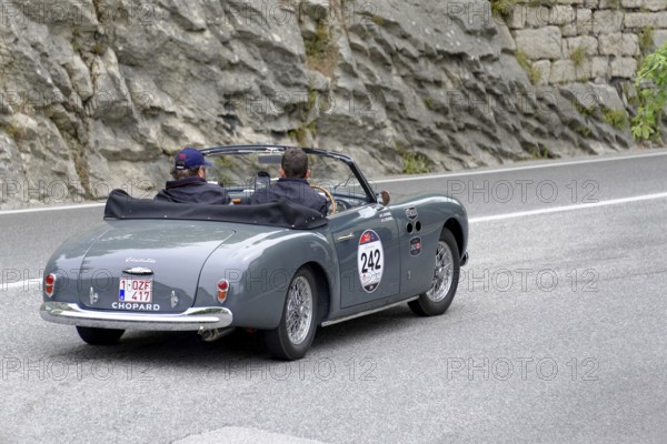 Grey vintage convertible driving on a road along rocky landscape, Mille Miglia 2014 or 1000 Miglia,
