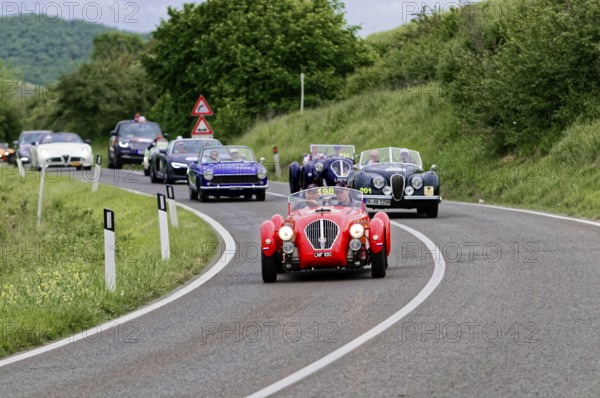 Group of classic cars driving in a row on a winding country road, classic car, car race, Mille
