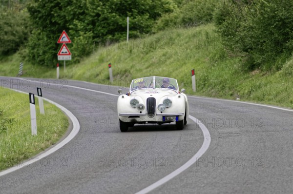 Classic car in white colour drives on winding country road, classic car, car race, Mille Miglia,