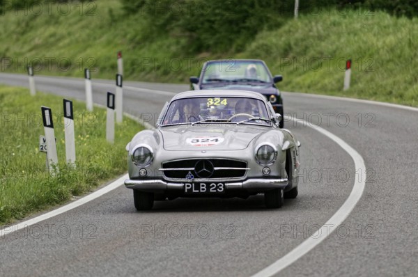Silver classic car on a winding, rural road accompanied by a blue car, classic car, car race, Mille