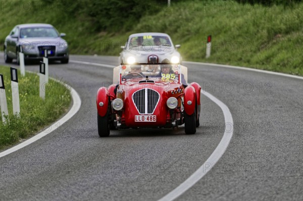 Red classic car on a winding country road at dusk, classic car, car race, Mille Miglia, 1000