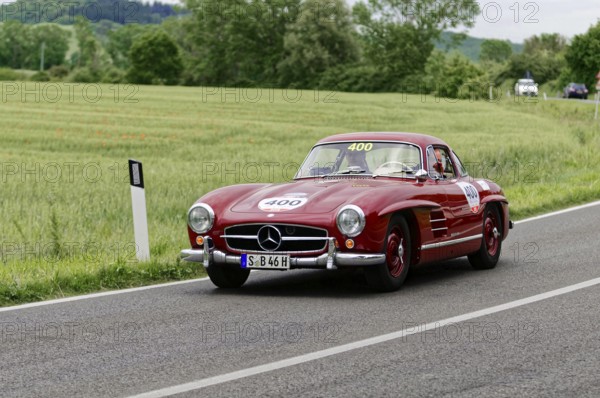 The red Mercedes classic car continues its journey on the sweeping country road, classic car, car