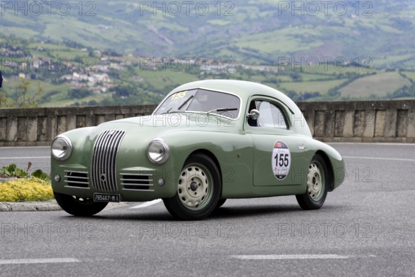 No. 155, FIAT 1100 S berlinetta Gobbone, Green vintage car drives on a road with a rural backdrop,