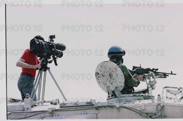 BIH, Tuzla, 01.05.1993 -- A cameraman and a British UN soldier wait for refugees from Srebrenica to