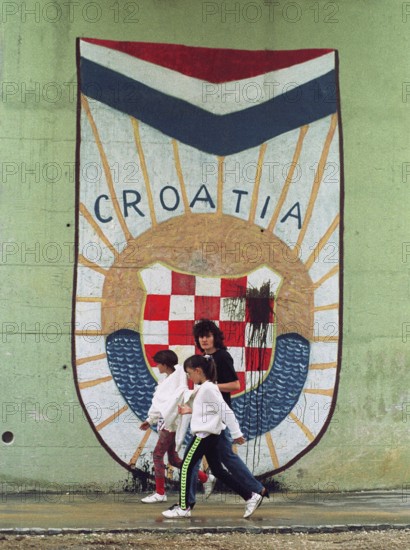 HRV, Split, 01.10.1991 -- Passers-by walk past the Croatian national coat of arms at an underpass