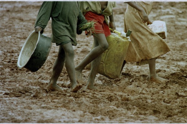 RWA, Benaco camp, 19.05.1994 -- Refugee children wander through the muddy paths of the Benaco camp
