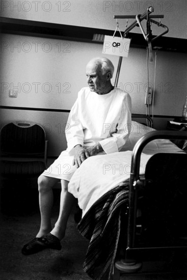 Berlin, DEU, 17.05.1998 -- ENT department, a patient (82 years old) sits on his hospital bed with
