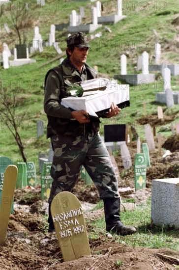 BIH, Bosnia, Tuzla, 07.05.1993 A Bosnian soldier is burying a child's coffin. The toddler was
