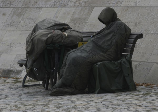 DEU Germany Germany Berlin A homeless person sits on the banks of the Spree opposite the Federal