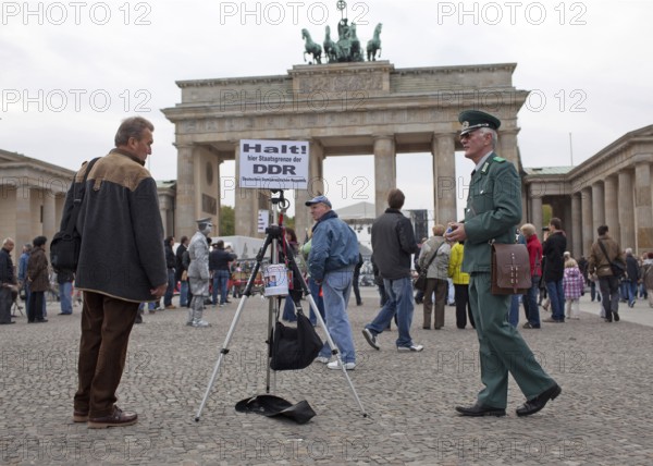 DEU Germany Berlin fundraisers in GDR uniform with a state border sign. The Lord collects donations