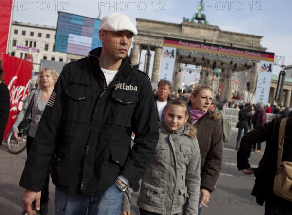 DEU Germany Berlin People stroll in front of the Brandenburg Gate. Scene on the eve of the 20th