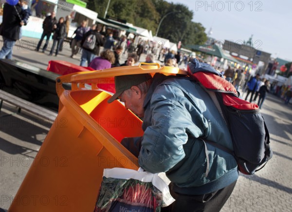 DEU Germany Berlin A collector checks the garbage cans for recyclable materials. Scene on the eve