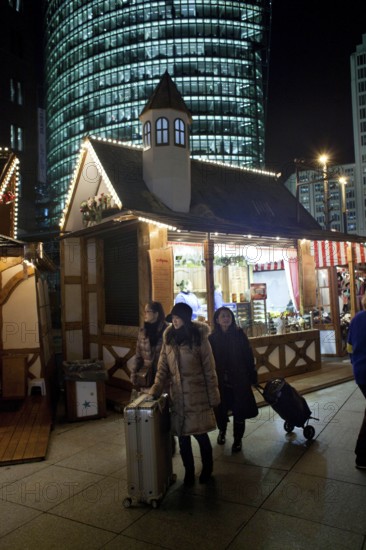 Berlin 2010-11-24 tourists with suitcases at the Christmas market at Potsdamer Platz DEU Berlin