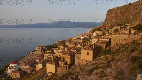 Soft morning light, medieval coastal town at sunrise with sea view and tiled roofs, Monemvasia,